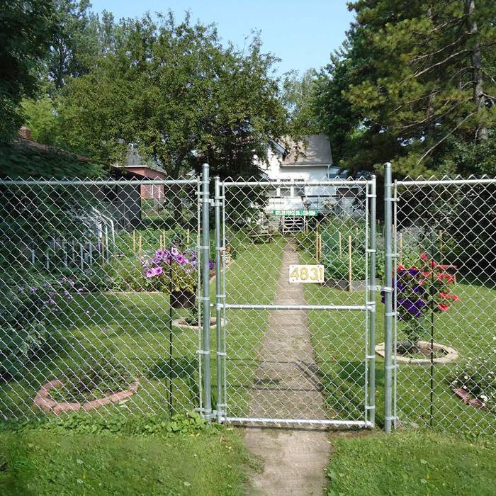 A piece of chain link single swing gate are installed in the garden.