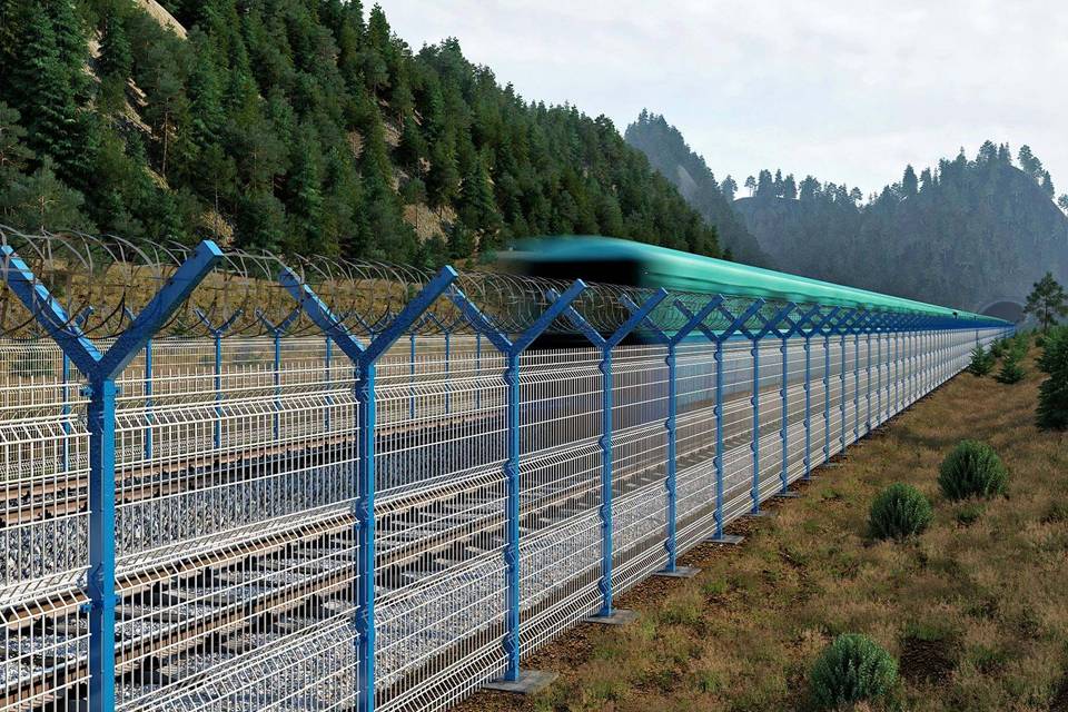A train is running on the railway track enclosed by curvy welded fence.