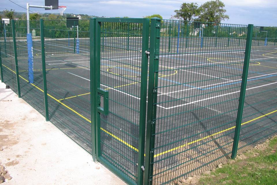 Double wire fences are installed around a basketball court.