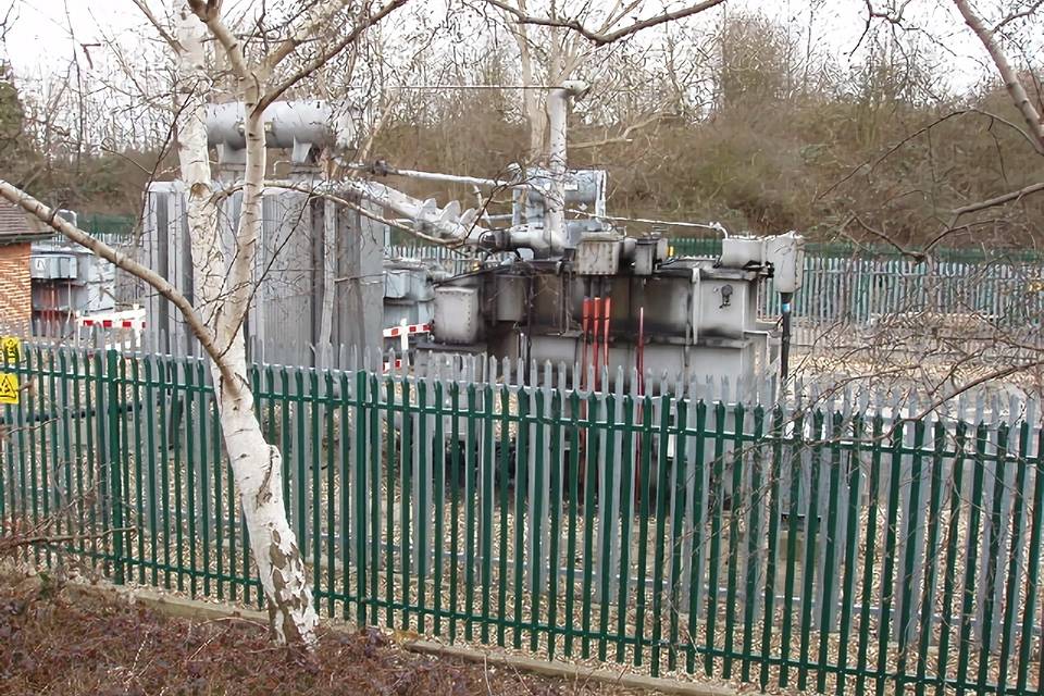 Power facilities are installed in the open air and enclosed by palisade fencing.