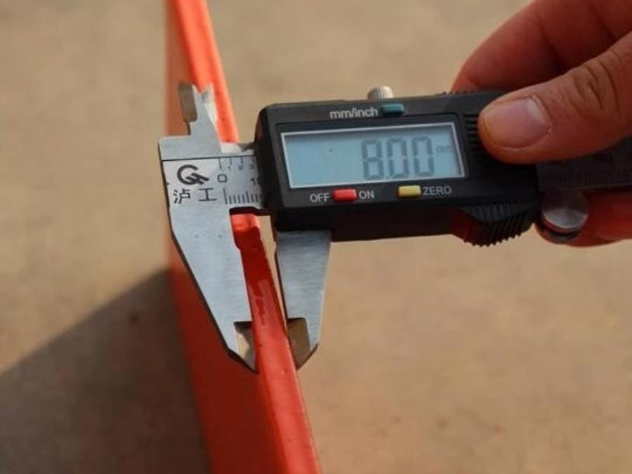 A man is measuring the feet thickness of Canada temporary fence.