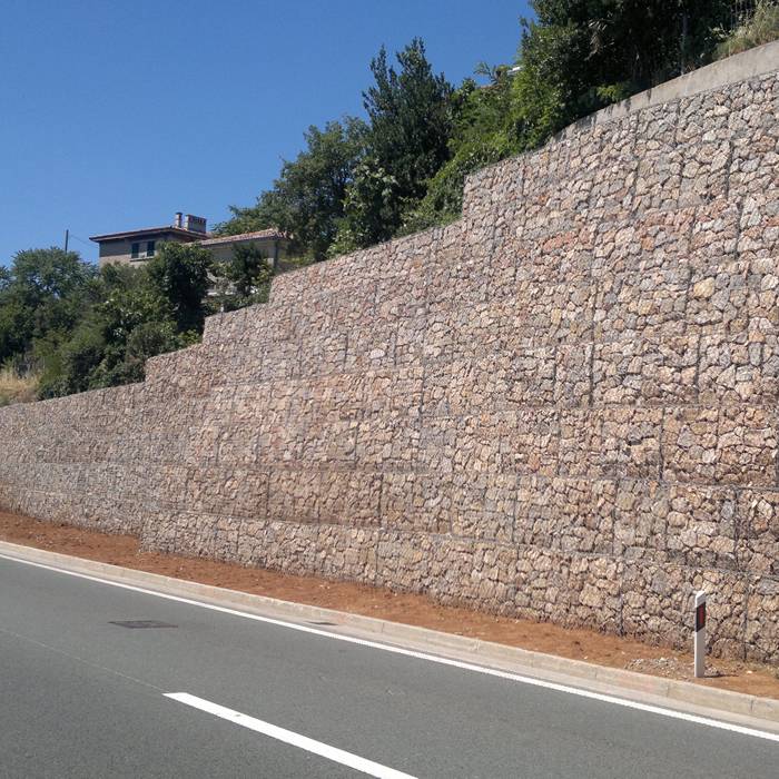 Several layers of woven gabion baskets are installed beside of the road.